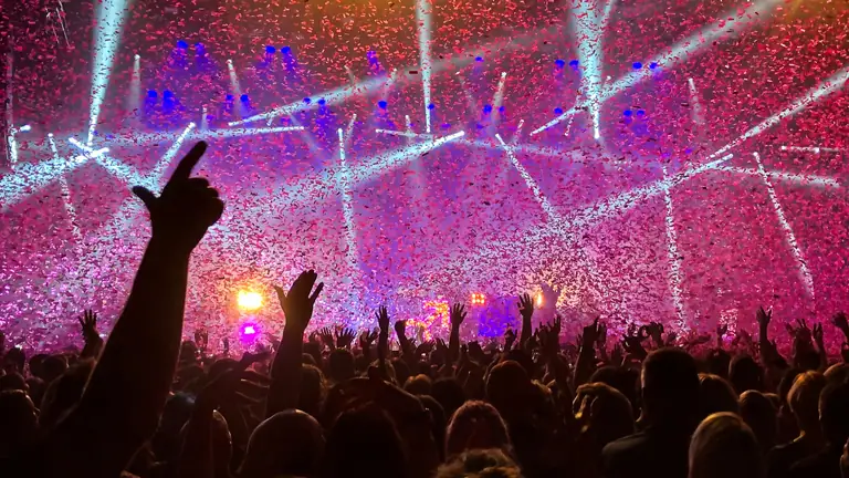 Lasers and confetti over a crowd.