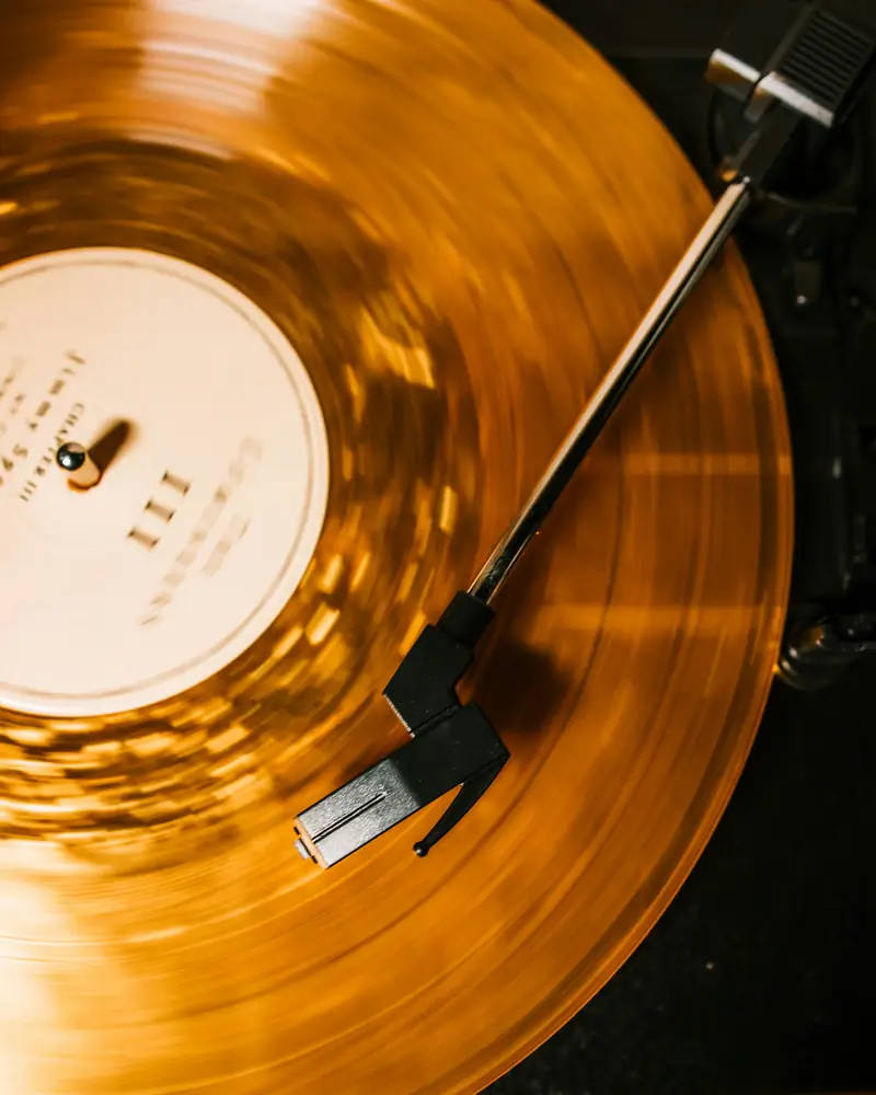 An amber vinyl record spinning on a turntable.